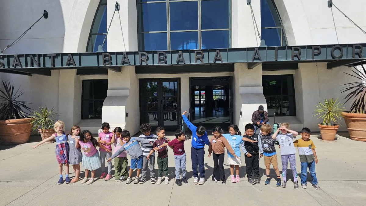 A group of kids pose in front of the terminal entrance.